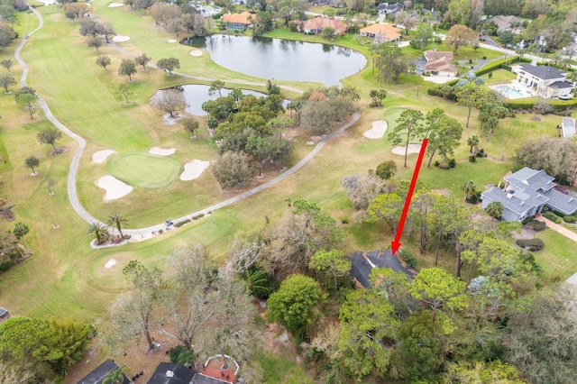 drone / aerial view featuring golf course view and a water view