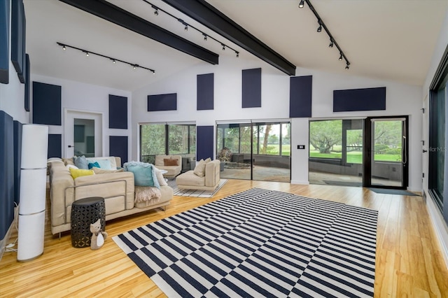 living area featuring high vaulted ceiling, beam ceiling, wood finished floors, and rail lighting