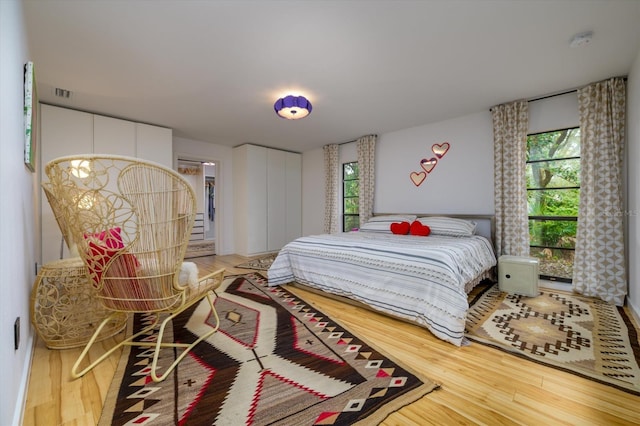 bedroom featuring visible vents and wood finished floors