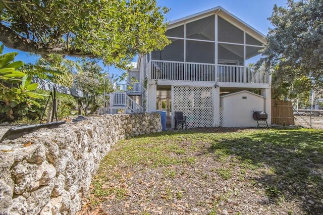 rear view of house with a sunroom and a yard