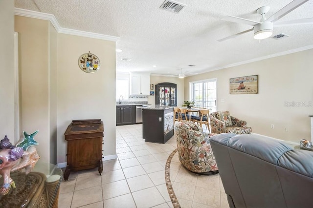 living room featuring light tile patterned floors, crown molding, a textured ceiling, and ceiling fan