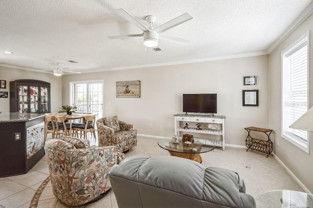 tiled living room featuring ornamental molding, ceiling fan, and a textured ceiling