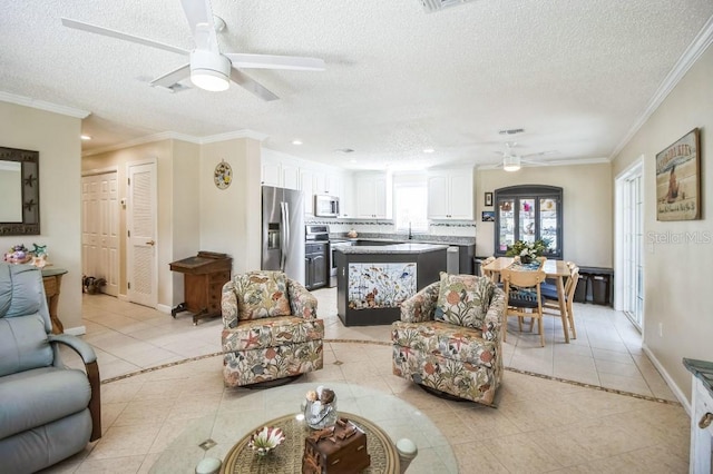 tiled living room with a textured ceiling, ornamental molding, and ceiling fan