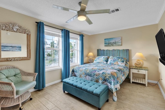 bedroom with ceiling fan, crown molding, a textured ceiling, and light hardwood / wood-style flooring