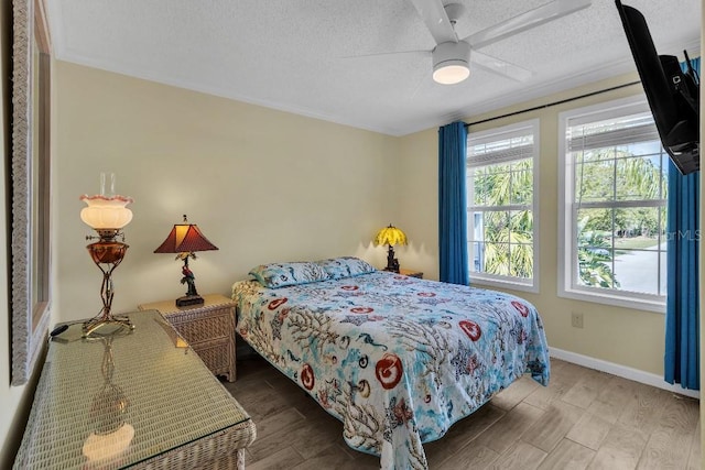 bedroom featuring ceiling fan, hardwood / wood-style floors, and a textured ceiling