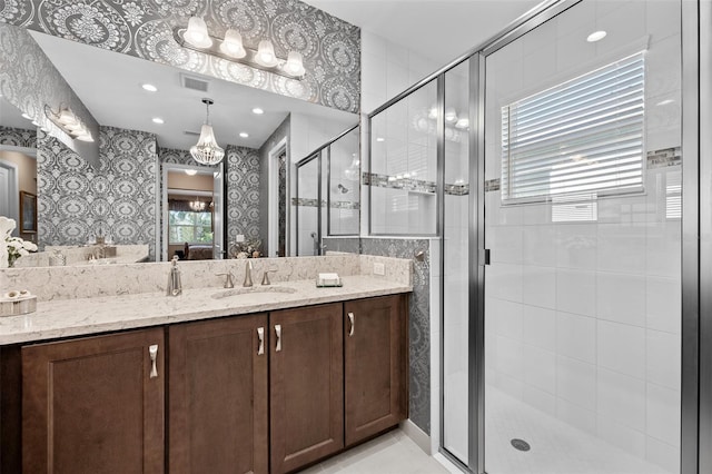 bathroom with a shower with door and vanity