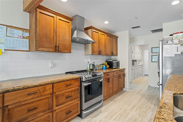 kitchen with light wood-style floors, stainless steel appliances, visible vents, and extractor fan