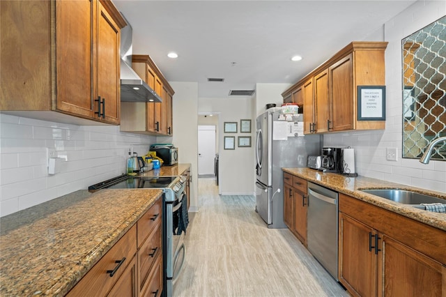 kitchen featuring appliances with stainless steel finishes, brown cabinets, a sink, and visible vents