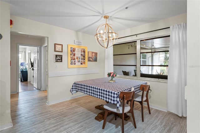 dining room featuring baseboards, an inviting chandelier, and wood finished floors