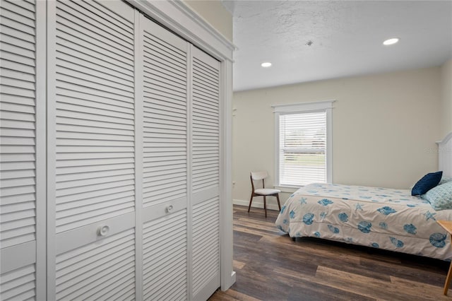 bedroom featuring baseboards, dark wood finished floors, a textured ceiling, a closet, and recessed lighting