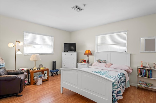 bedroom with visible vents, light wood finished floors, and multiple windows