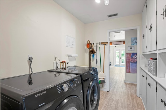 laundry area featuring cabinet space, visible vents, light wood-style flooring, separate washer and dryer, and baseboards