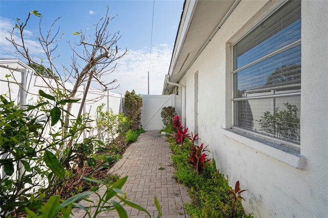 view of side of property with fence and stucco siding