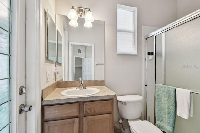 bathroom with vanity, toilet, and walk in shower