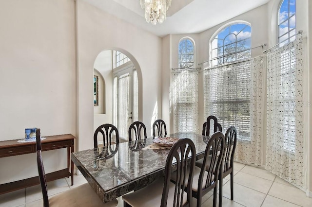 dining area with a notable chandelier and light tile patterned floors