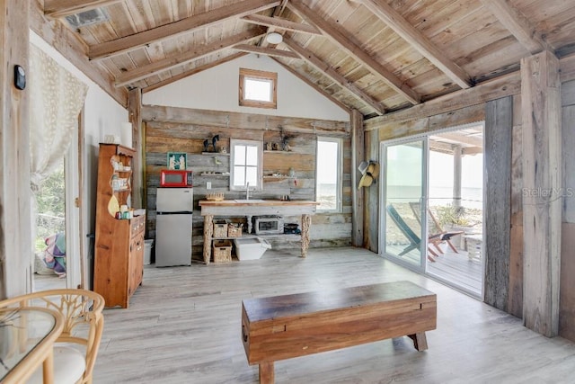 living area featuring light wood-style floors, wooden ceiling, high vaulted ceiling, and beam ceiling