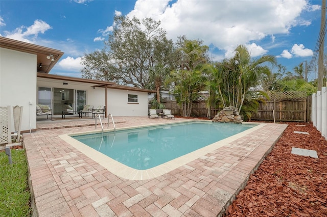 view of swimming pool featuring a fenced in pool, a fenced backyard, and a patio area