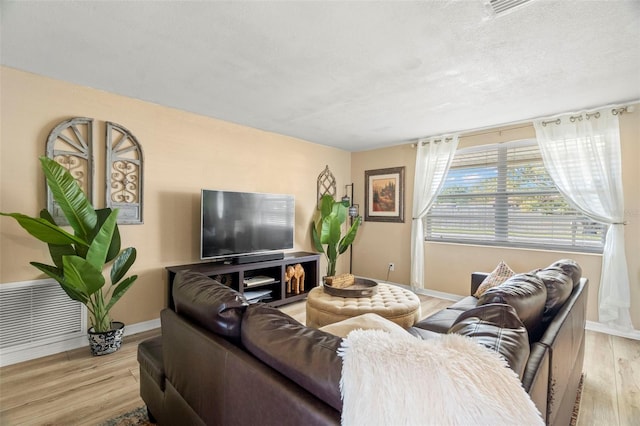 living room with light hardwood / wood-style floors and a textured ceiling