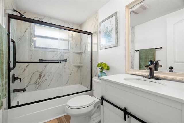 full bathroom with vanity, wood-type flooring, shower / bath combination with glass door, and toilet