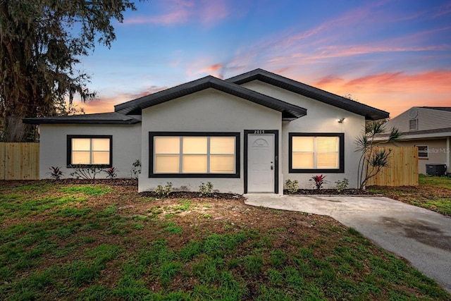 ranch-style home featuring a yard and central air condition unit