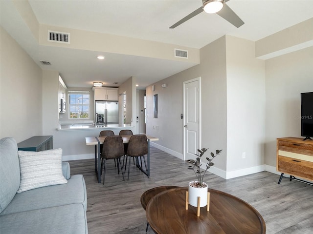 living room featuring sink, ceiling fan, and light wood-type flooring