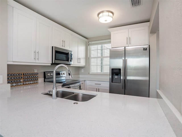kitchen with white cabinetry, appliances with stainless steel finishes, and sink