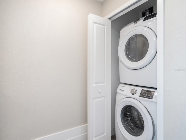 clothes washing area featuring stacked washer / dryer