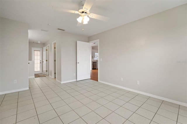 unfurnished room with a healthy amount of sunlight, light tile patterned floors, and ceiling fan