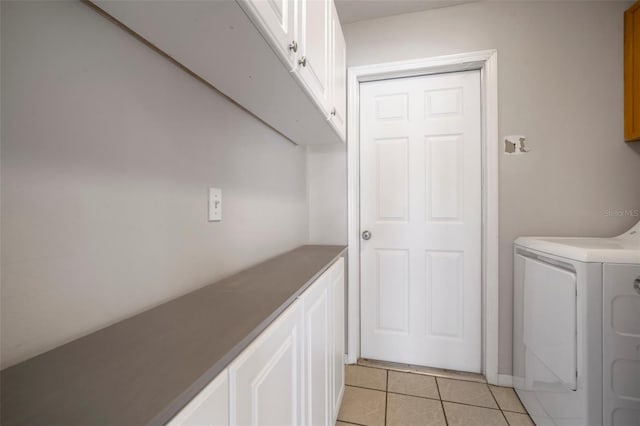 washroom with cabinets, washer / dryer, and light tile patterned floors