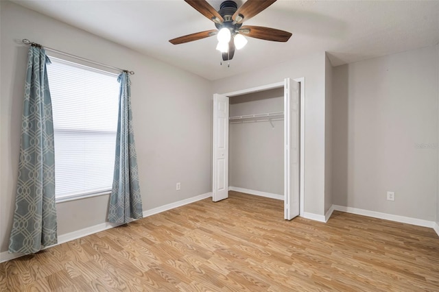 unfurnished bedroom featuring multiple windows, light hardwood / wood-style flooring, a closet, and ceiling fan