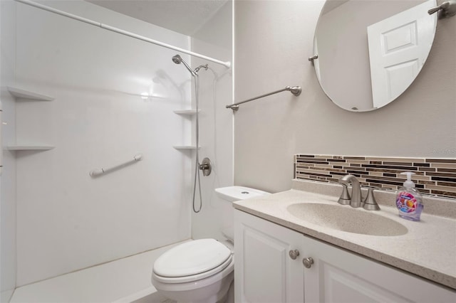 bathroom featuring tasteful backsplash, vanity, toilet, and a shower