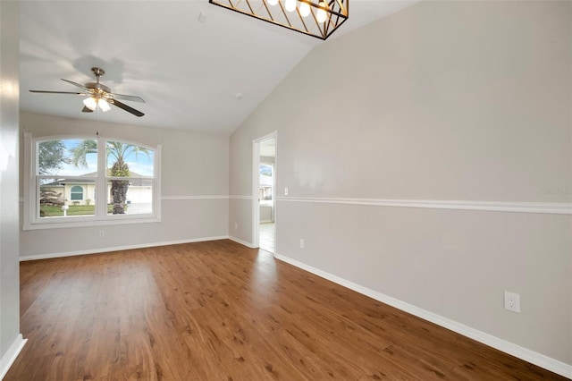 empty room with ceiling fan with notable chandelier, lofted ceiling, and hardwood / wood-style floors