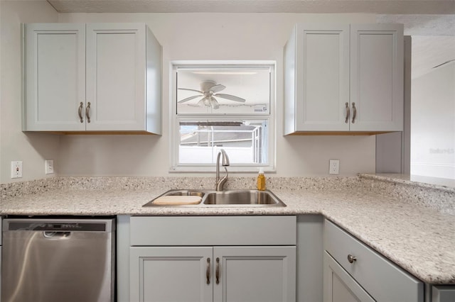 kitchen with sink, ceiling fan, light stone countertops, a textured ceiling, and stainless steel dishwasher