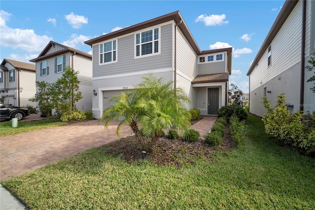 view of front of home with a garage, a front lawn, decorative driveway, and stucco siding