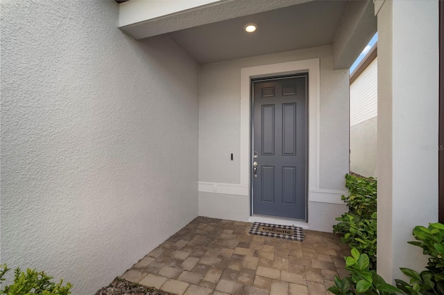 view of exterior entry featuring stucco siding