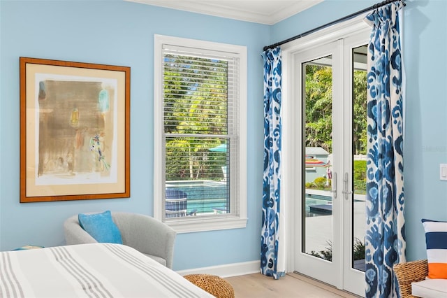 bedroom featuring access to exterior, ornamental molding, french doors, and light wood-type flooring