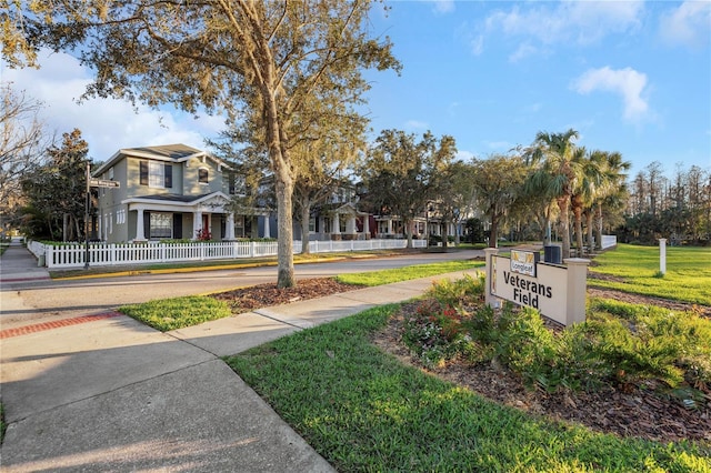 view of home's community with a yard and fence