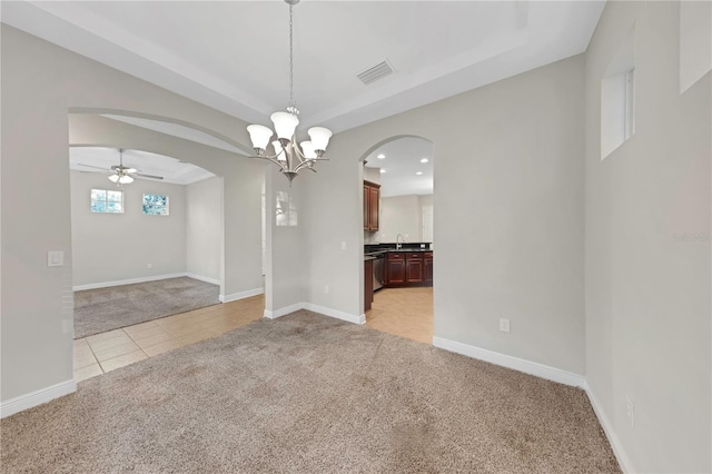 unfurnished room with arched walkways, light tile patterned floors, visible vents, light carpet, and a sink