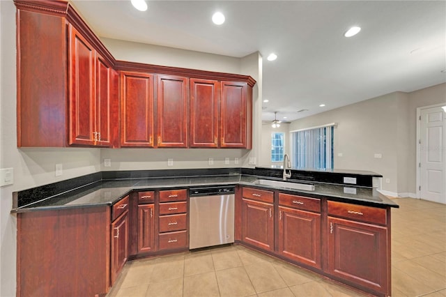 kitchen with reddish brown cabinets, dark stone counters, dishwasher, a peninsula, and a sink