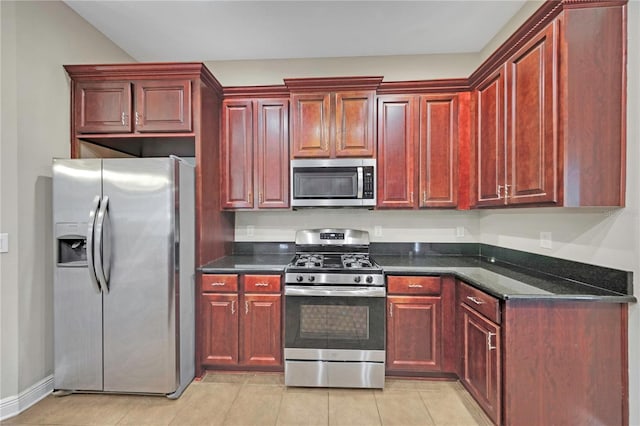 kitchen with light tile patterned floors, dark brown cabinets, and appliances with stainless steel finishes