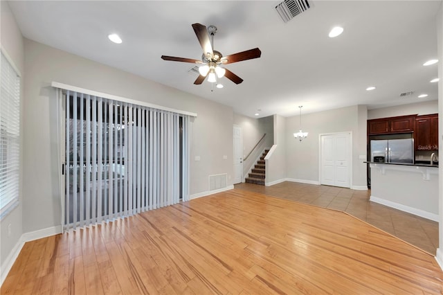 unfurnished living room with recessed lighting, visible vents, stairway, and light wood finished floors