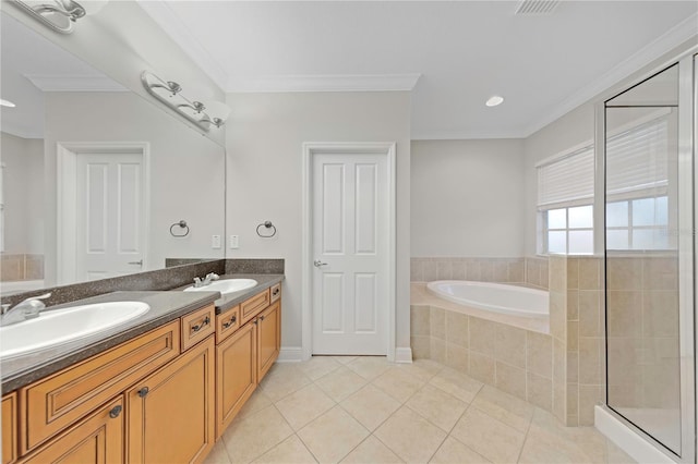 bathroom featuring a garden tub, crown molding, double vanity, a sink, and tile patterned flooring