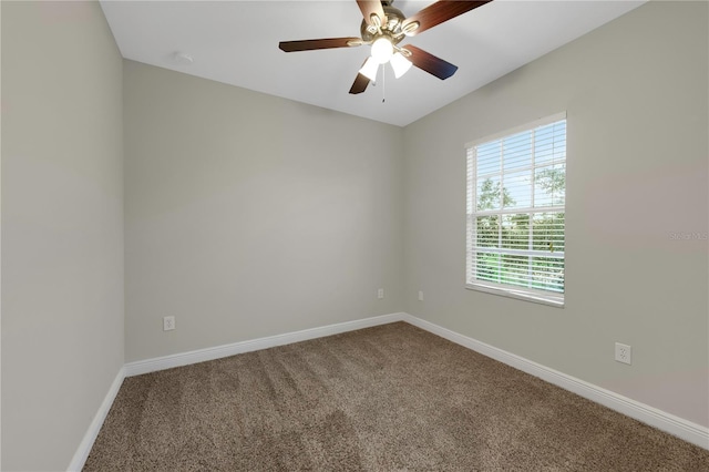 carpeted empty room with ceiling fan and baseboards