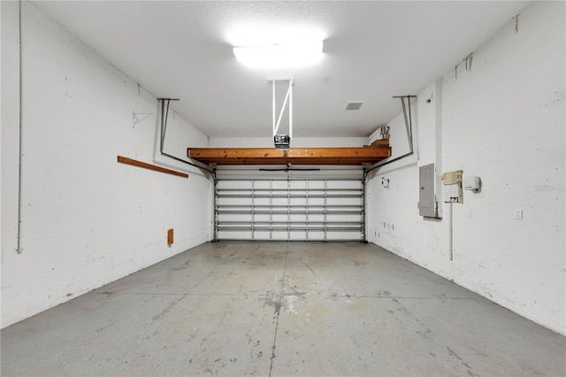 garage featuring electric panel, visible vents, and a garage door opener