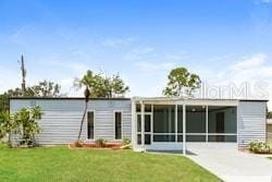 back of house with a sunroom and a yard