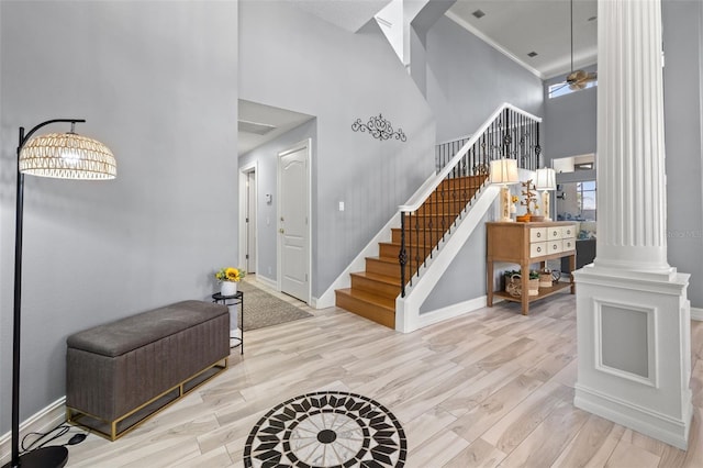 foyer with ornate columns, stairs, baseboards, and wood finished floors