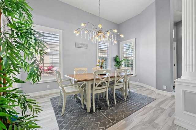 dining room featuring light wood-type flooring, baseboards, and an inviting chandelier