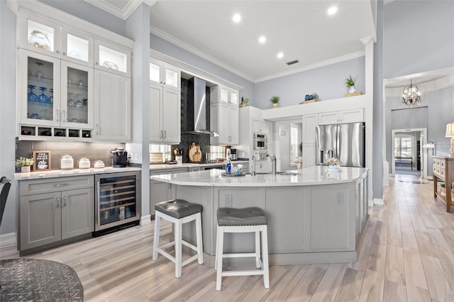 kitchen featuring wine cooler, stainless steel refrigerator with ice dispenser, tasteful backsplash, ornamental molding, and wall chimney exhaust hood