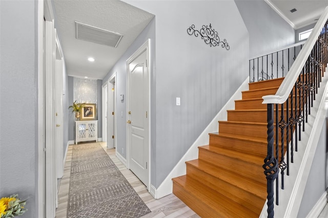 stairs featuring recessed lighting, wood finished floors, visible vents, and baseboards