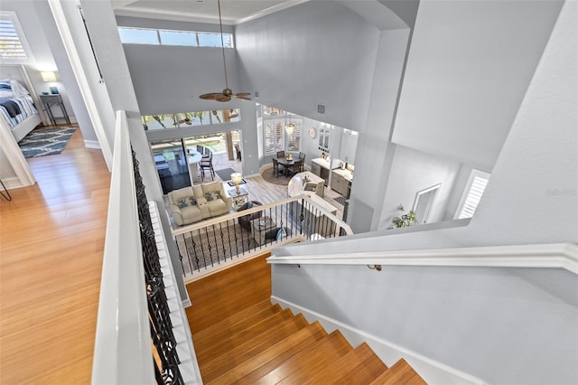 stairs featuring visible vents, wood finished floors, a ceiling fan, and baseboards